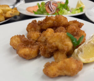 Battered food with a garnish of lemon and parsley.